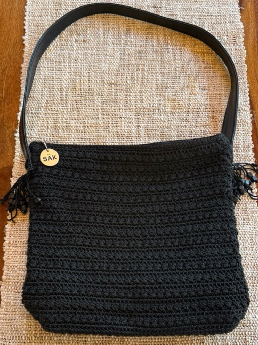 The Sak Black Crochet Shoulder Bag with Tassel Charm